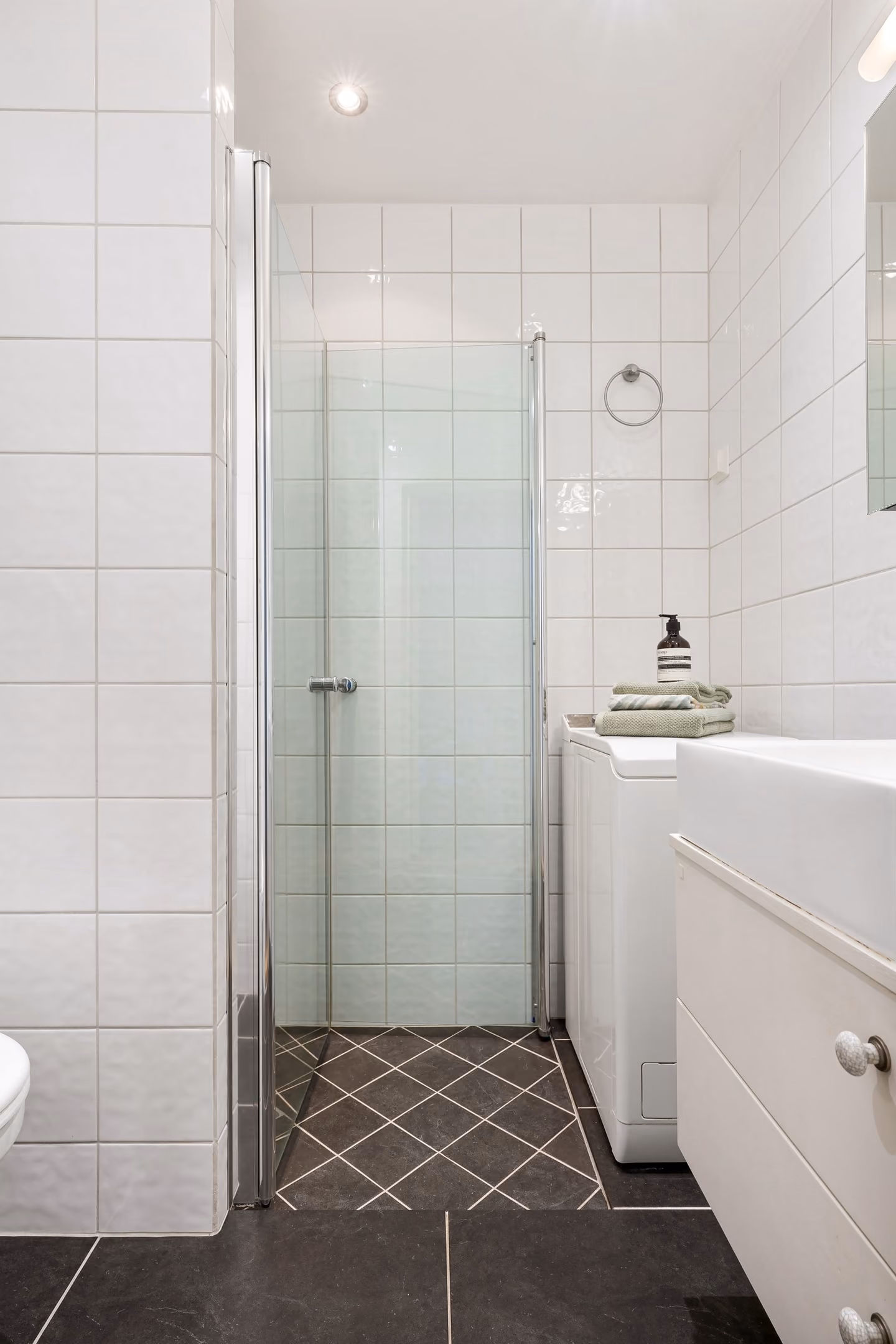 Plan real clearances, right-sized fixtures, useful storage, and finishes that support a compact room.