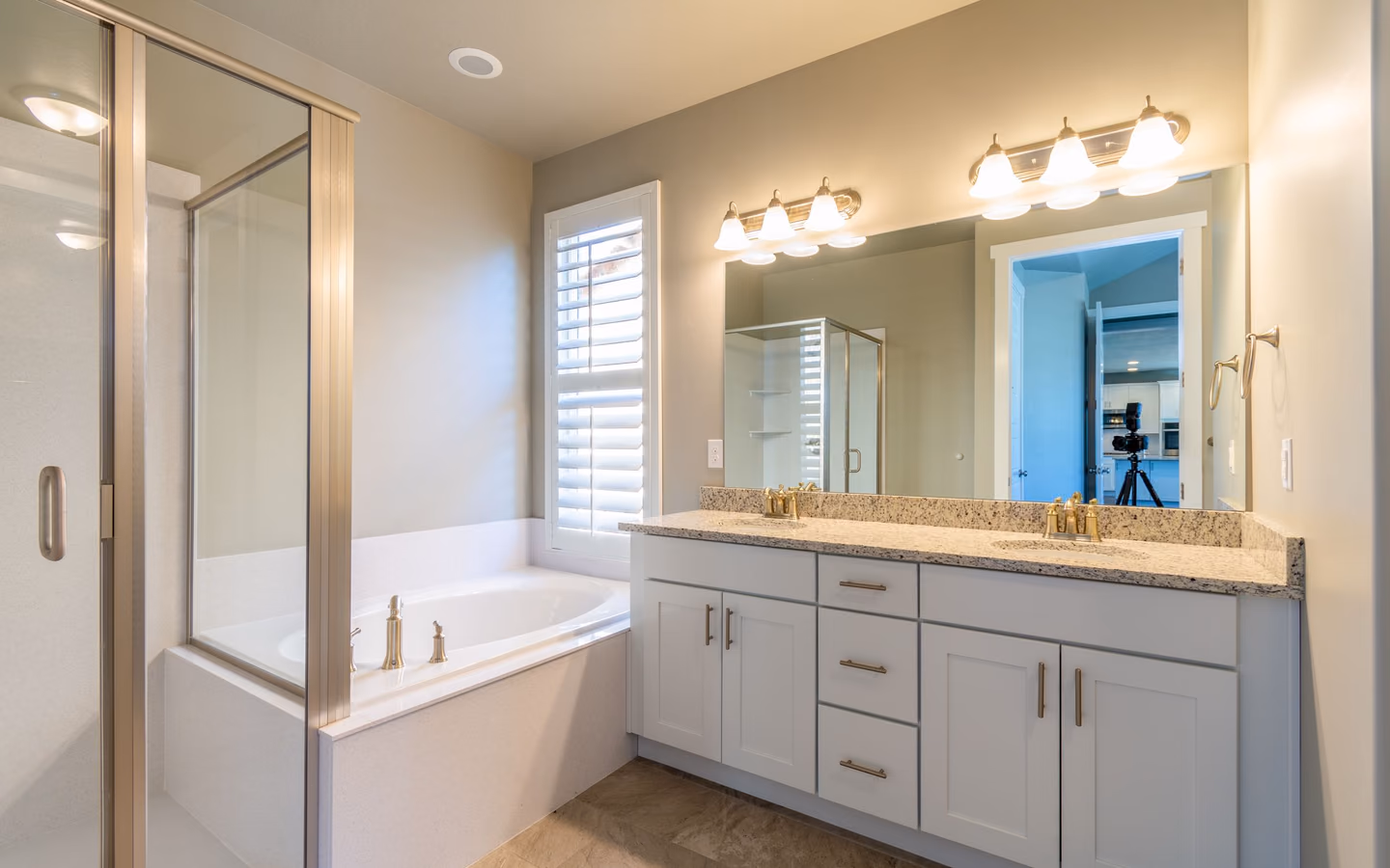 Bright renovated bathroom with a glass shower, freestanding tub, and double vanity