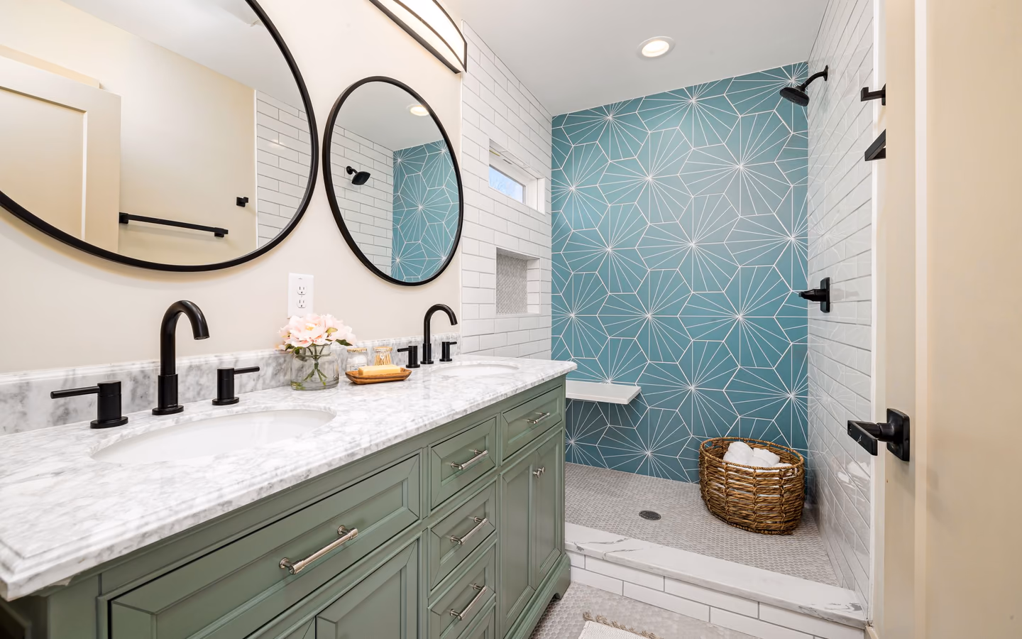 Updated transitional bathroom with a green double vanity, black hardware, and patterned shower tile