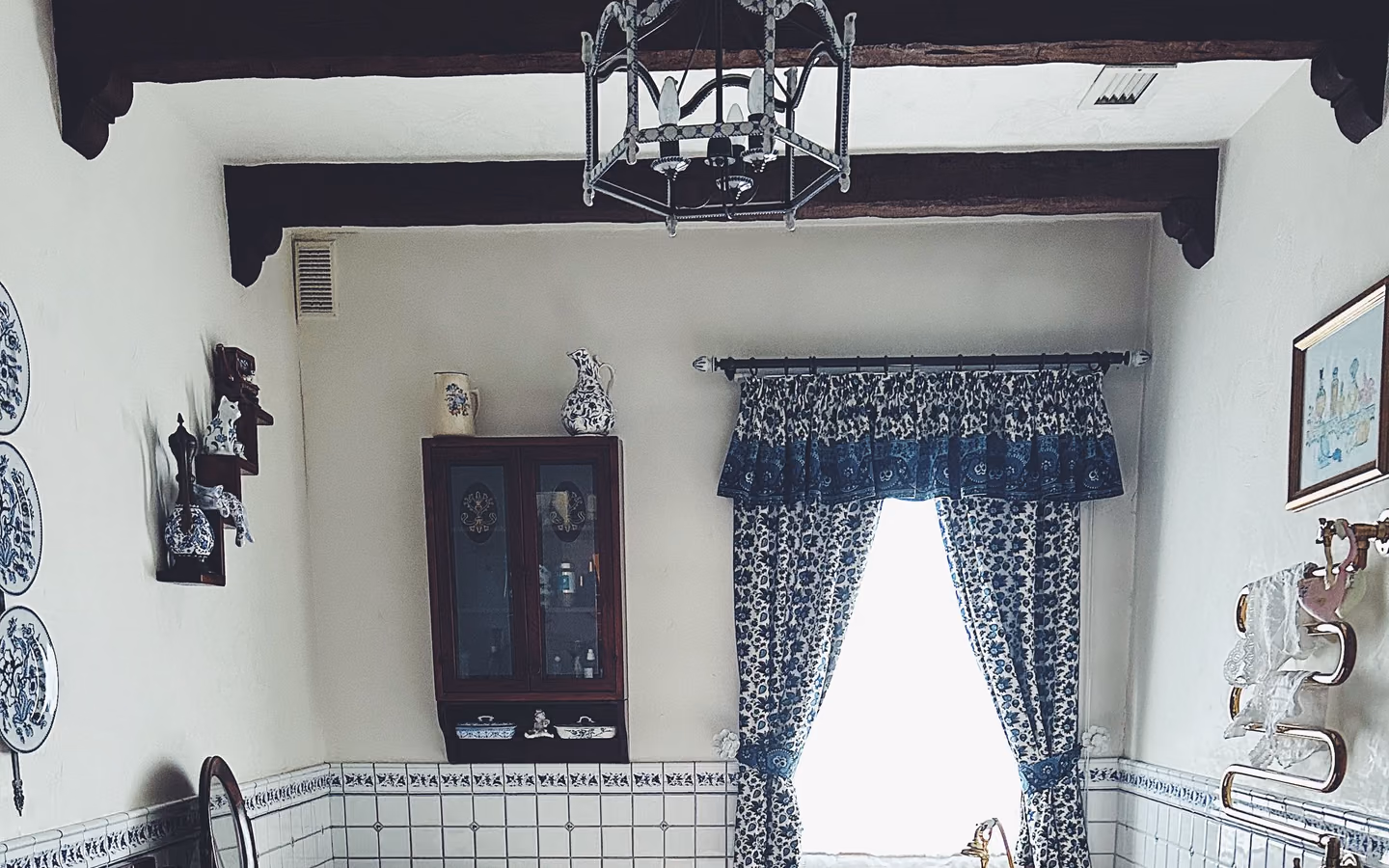 Traditional bathroom with a classic clawfoot tub, patterned tile, and natural window light