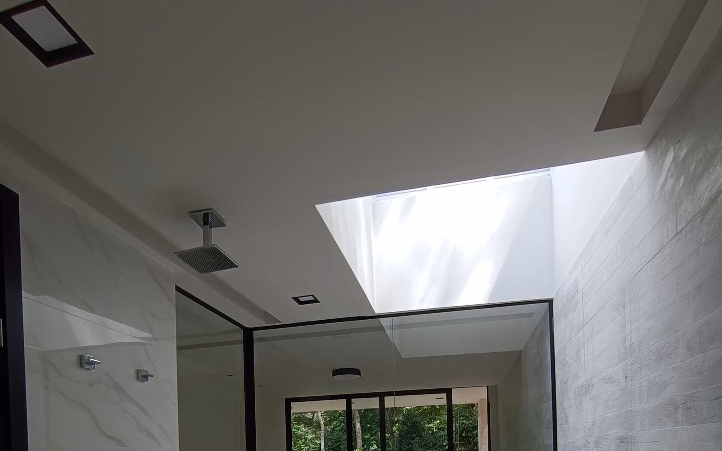 Luxury spa bathroom with a sculptural tub, floor-to-ceiling stone, and a framed garden view