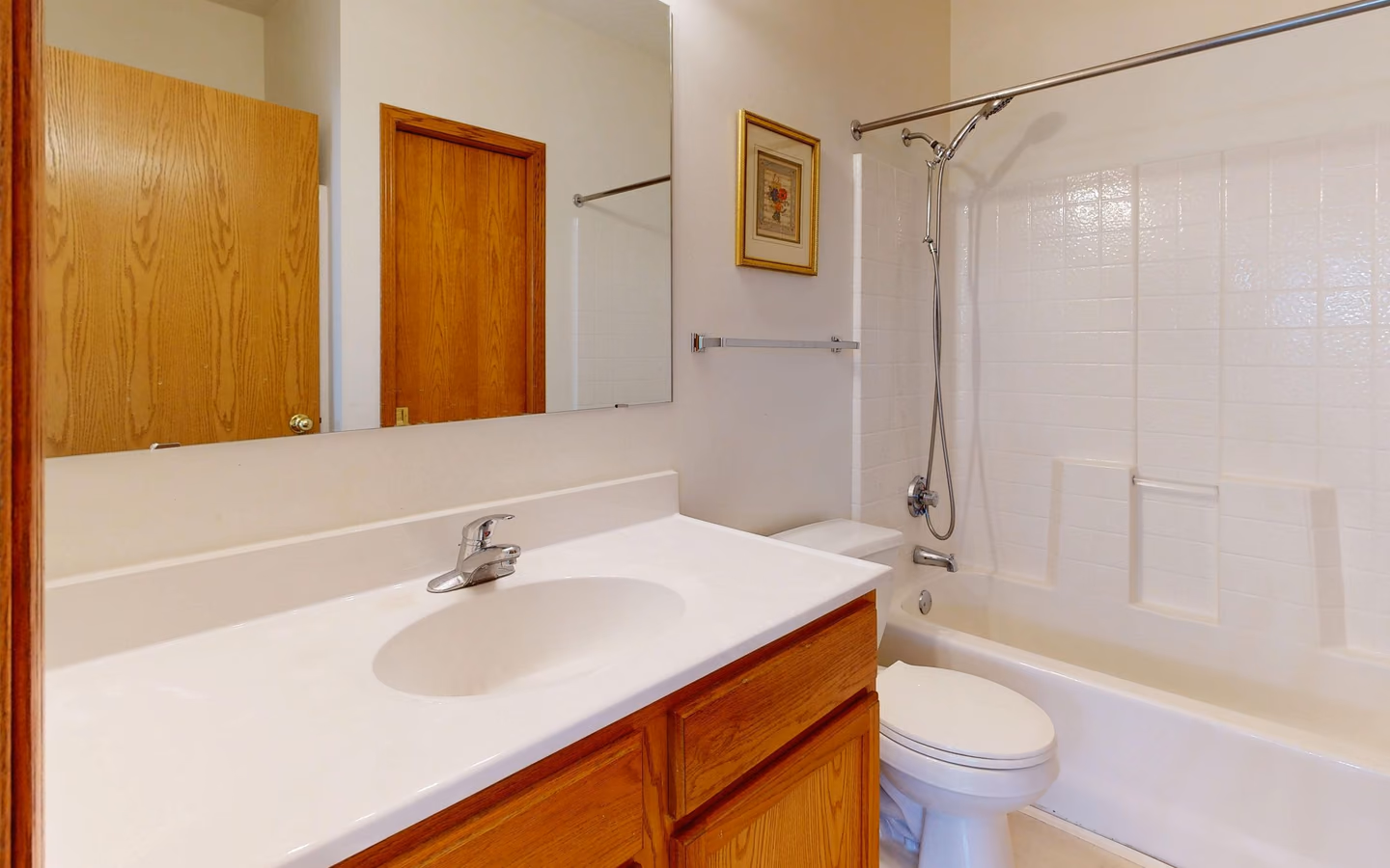 Bright renovated bathroom with wood cabinetry, a glass shower, and modern fixtures