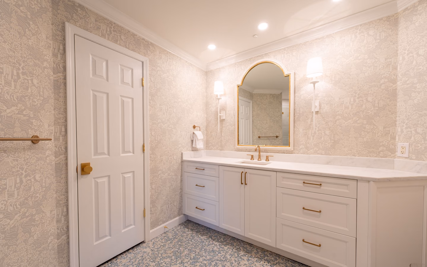 Refined traditional bathroom with a tailored white vanity, classic mirror, and marble-look surfaces
