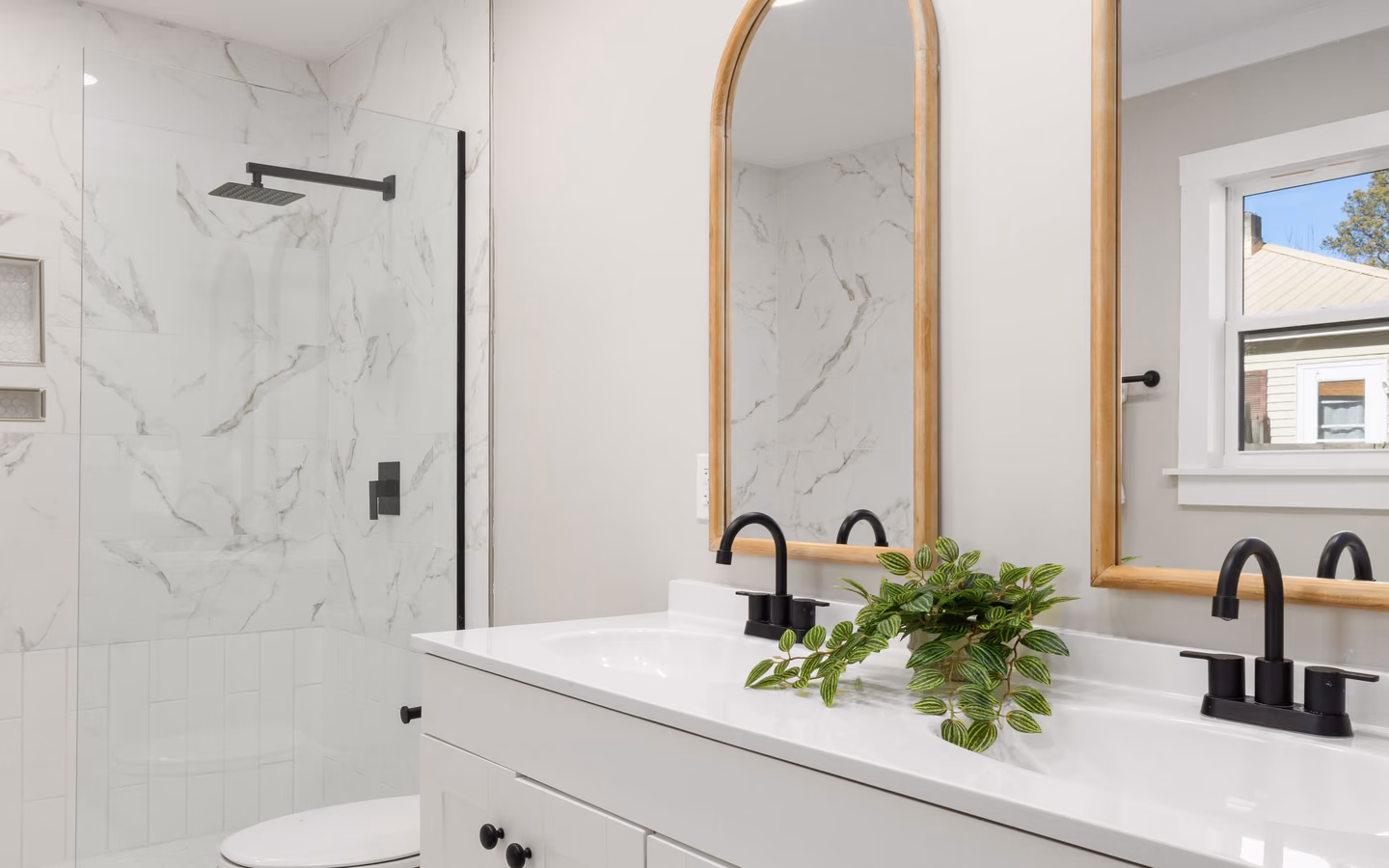 Bright modern bathroom with a long floating vanity, streamlined fixtures, and a crisp neutral palette