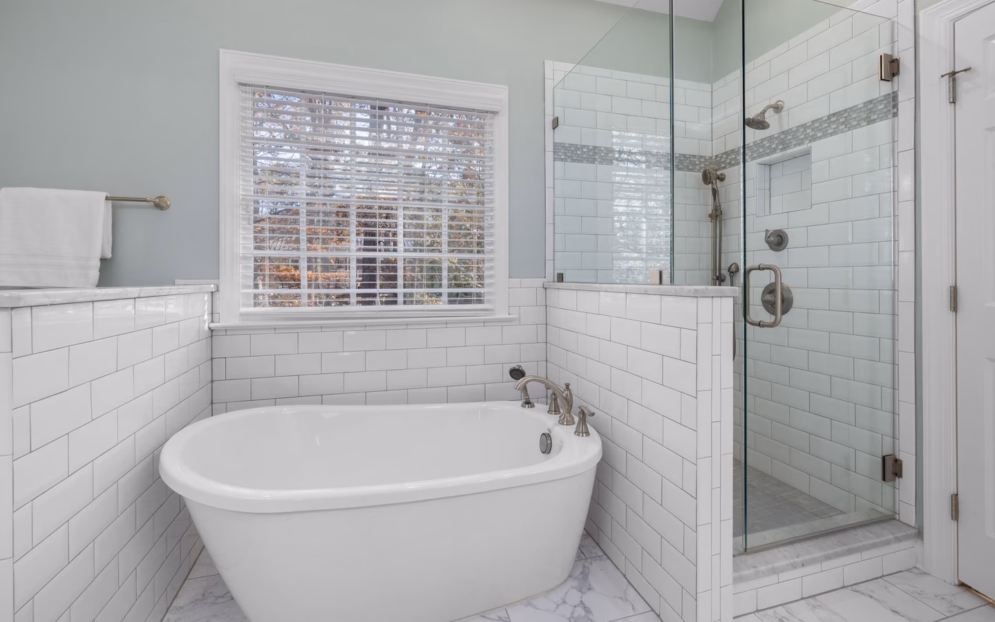 Sleek modern bathroom with a freestanding tub, glass shower, and bright natural light
