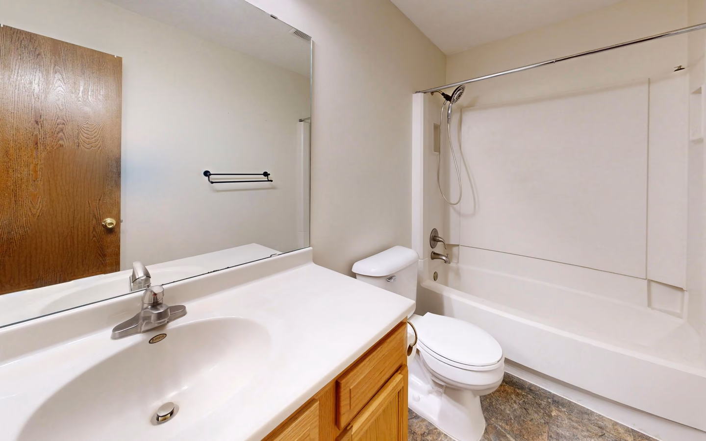 Bright renovated bathroom with a bathtub, streamlined vanity, and simple white finishes