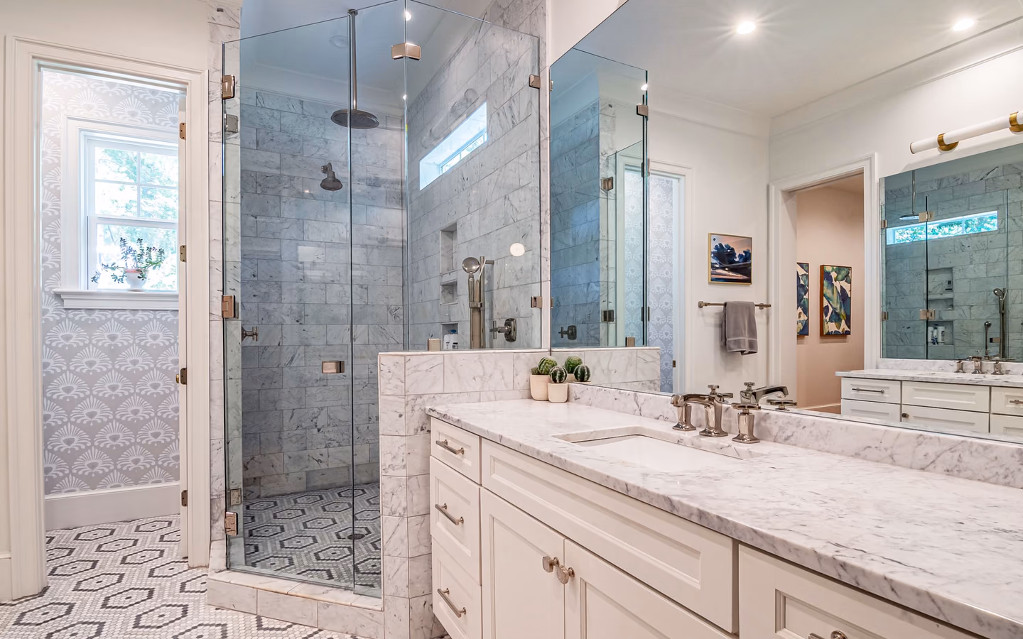 Mediterranean-inspired bathroom with marble counters, a glass shower, and patterned finishes