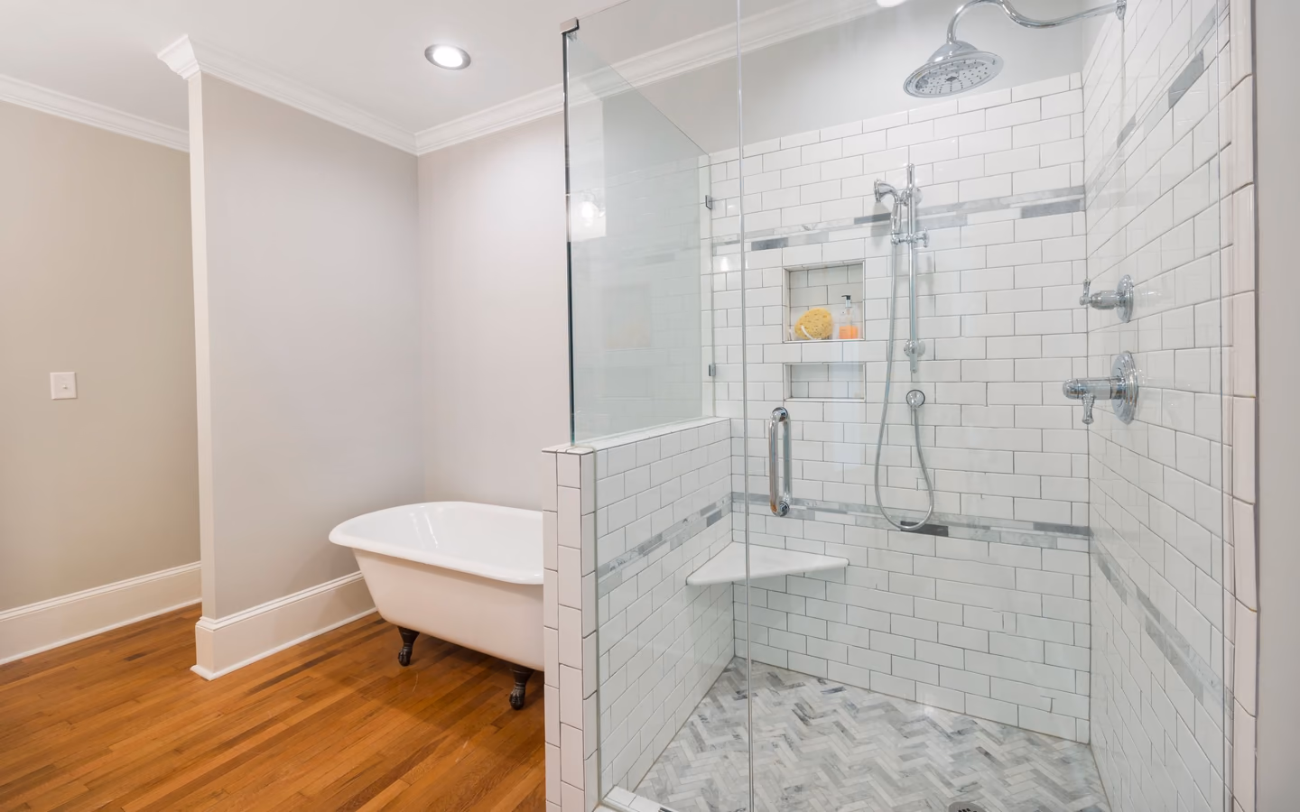 Spacious bathroom with a glass shower, freestanding tub, and warm wood flooring