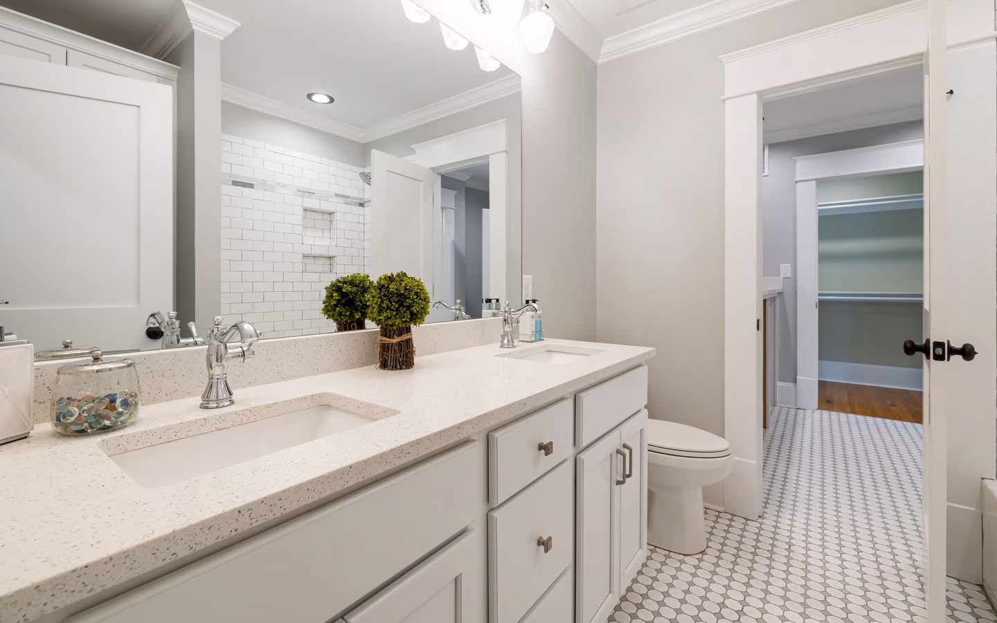 Bright modern bathroom with white fixtures, a long vanity, and restrained neutral decor