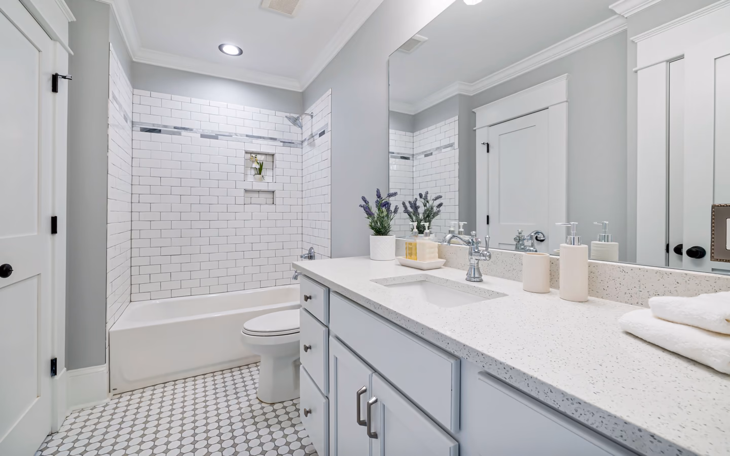 Contemporary white bathroom with subway tile, a bathtub, and streamlined fixtures