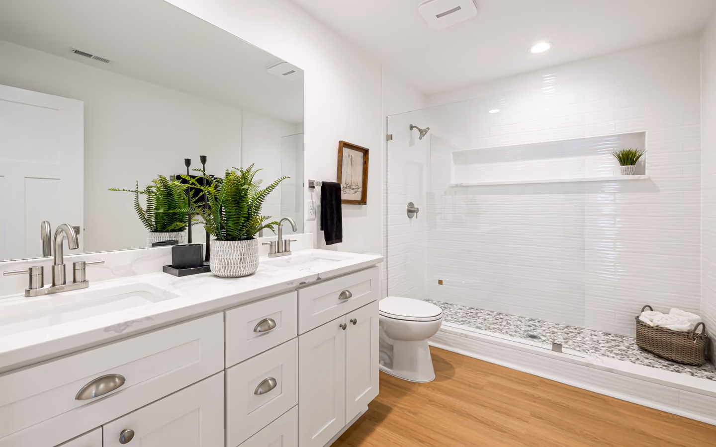 Organic modern bathroom with a double vanity, glass shower, indoor plants, and warm wood details
