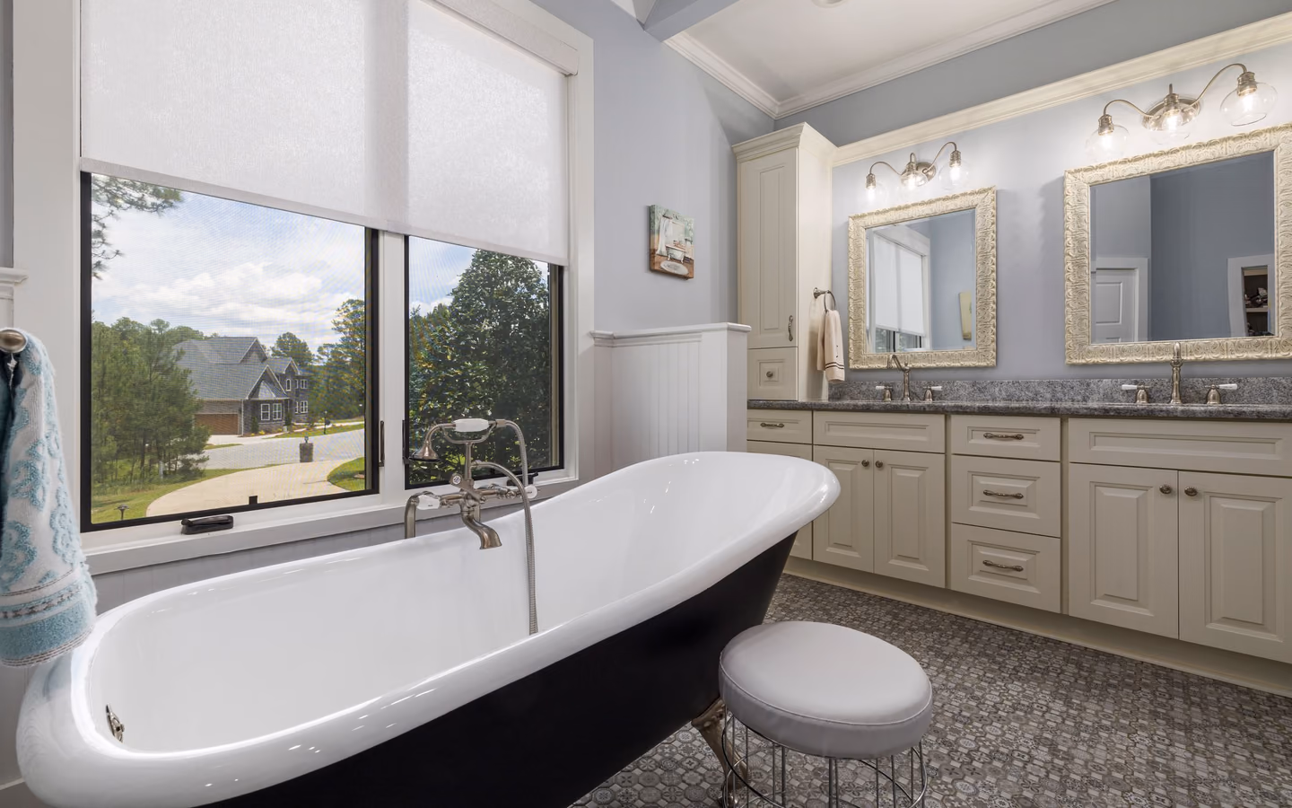 Serene spa bathroom with a freestanding tub, double vanity, and a leafy outdoor view