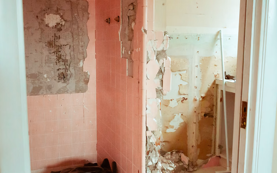 Bathroom renovation in progress with exposed framing and building materials