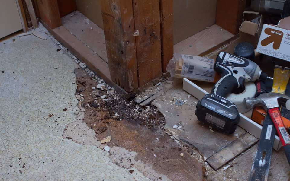 Damaged bathroom subfloor and framing exposed during demolition