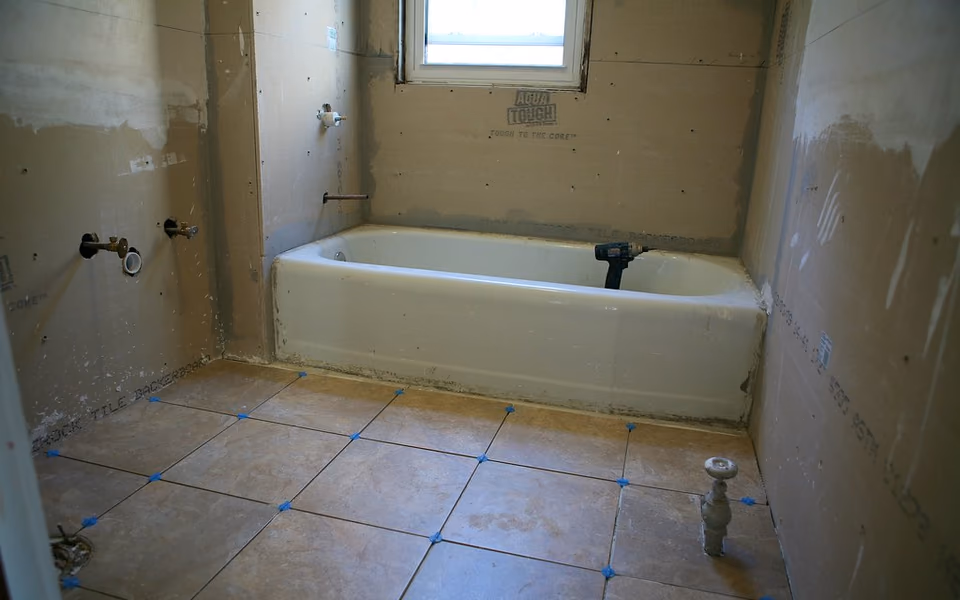 Small bathroom rough-in with new tub plumbing and unfinished wall surfaces