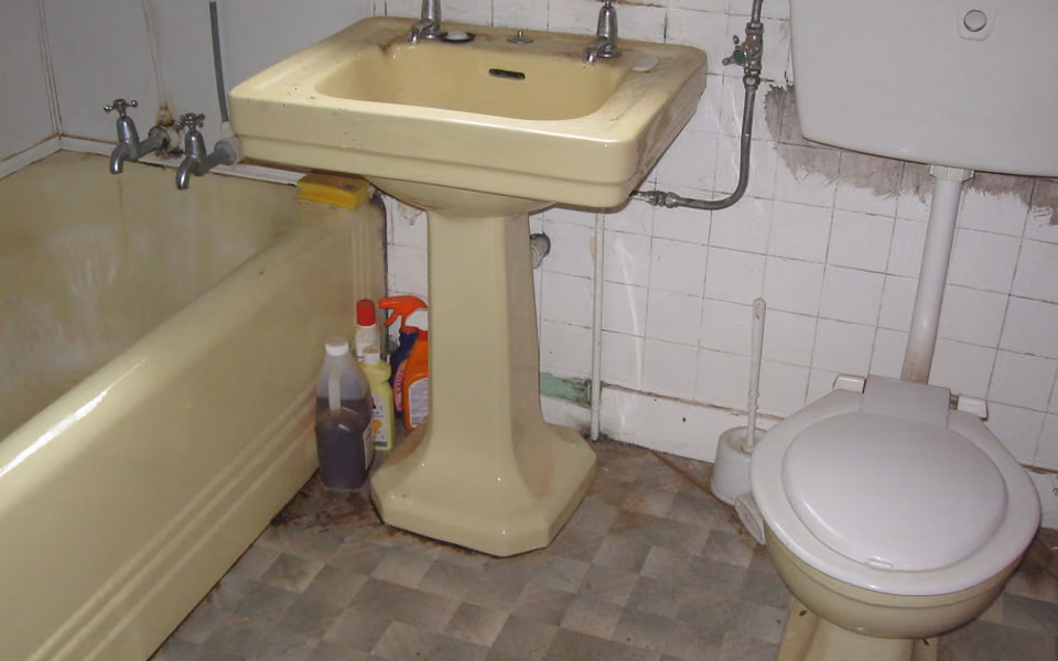 Dated bathroom before renovation with old fixtures and worn finishes