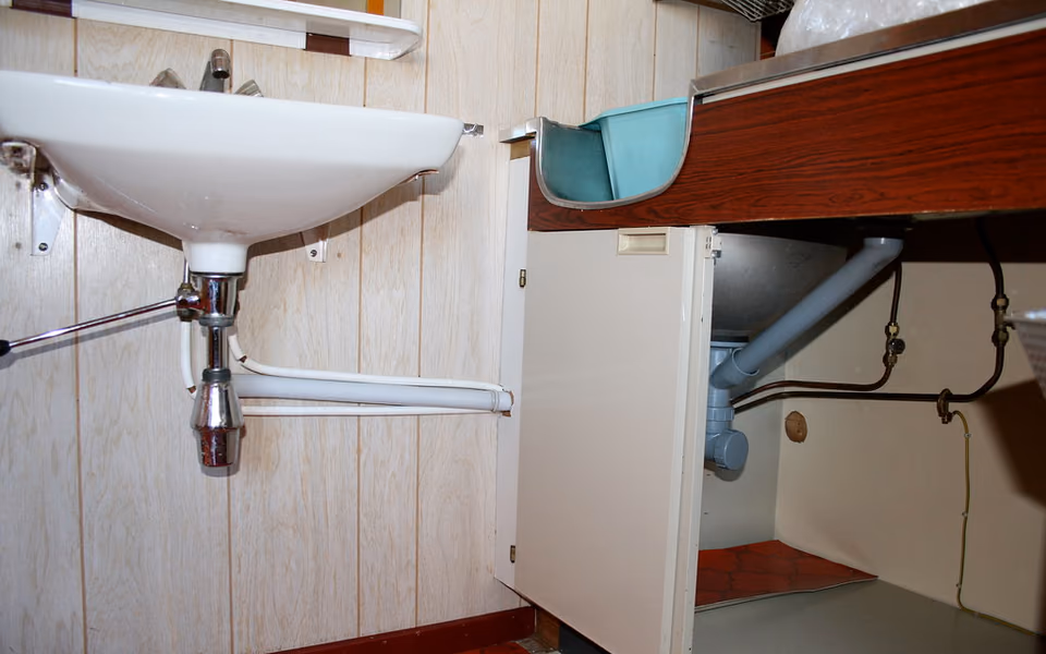 Bathroom renovation with plumbing routes exposed beneath the floor
