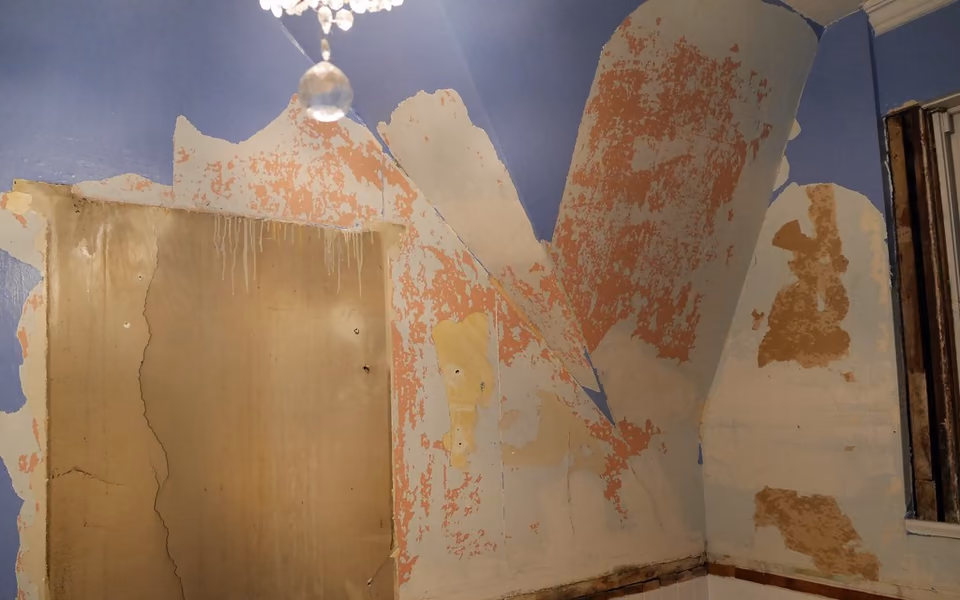Old bathroom wall finishes removed to expose multiple layers beneath