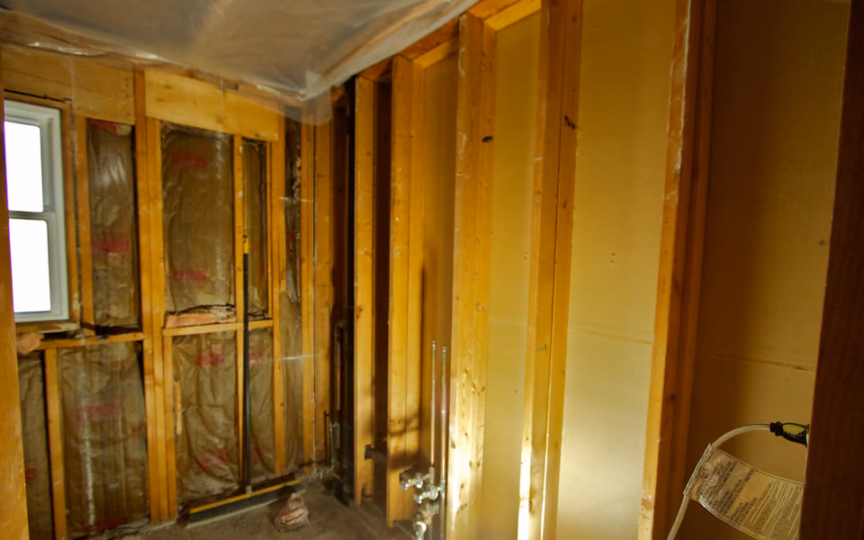 Bathroom stripped to wall studs at the start of a full renovation