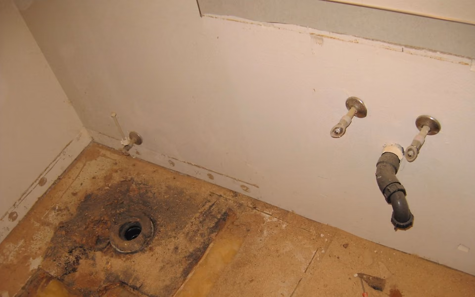 Bathroom cleared for renovation with fixtures and finished floor removed