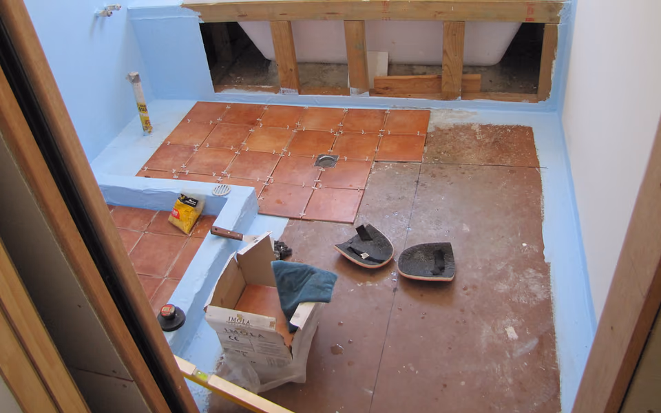 Bathroom floor tile being installed over a prepared substrate