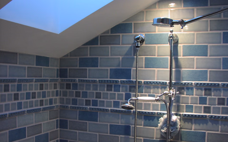 Enclosed tile shower with dual showerheads and overhead lighting